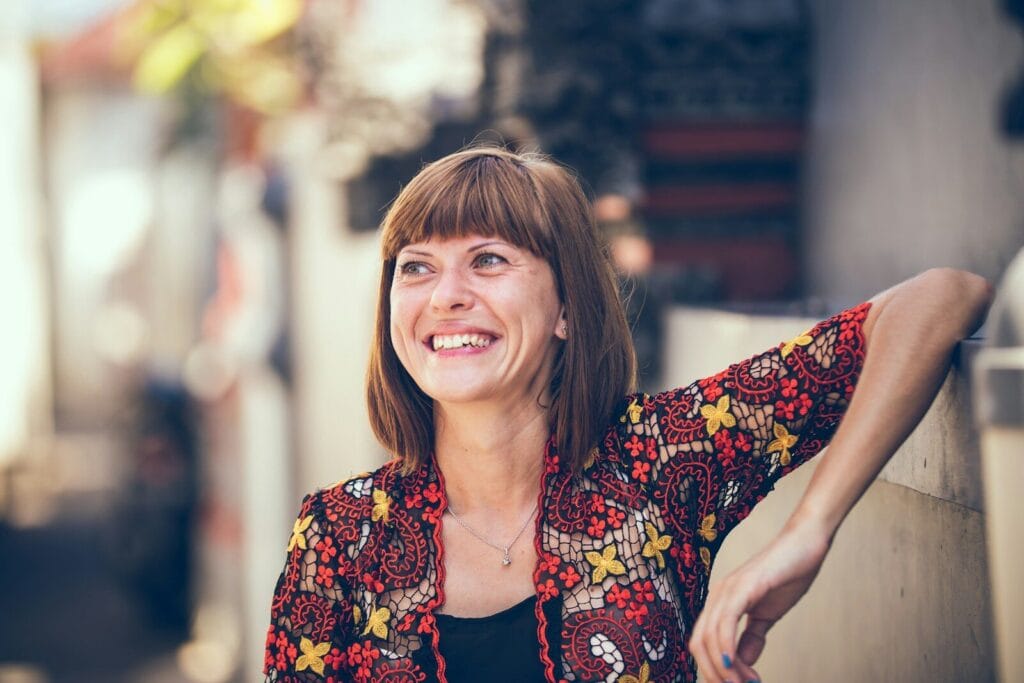 Landing page Policlinico Mangiagalli woman in floral-themed cardigan leaning on fence in bokeh photography